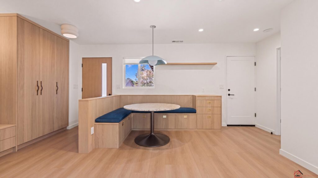 Built-in dining nook with curved blue seating and wood wall panels