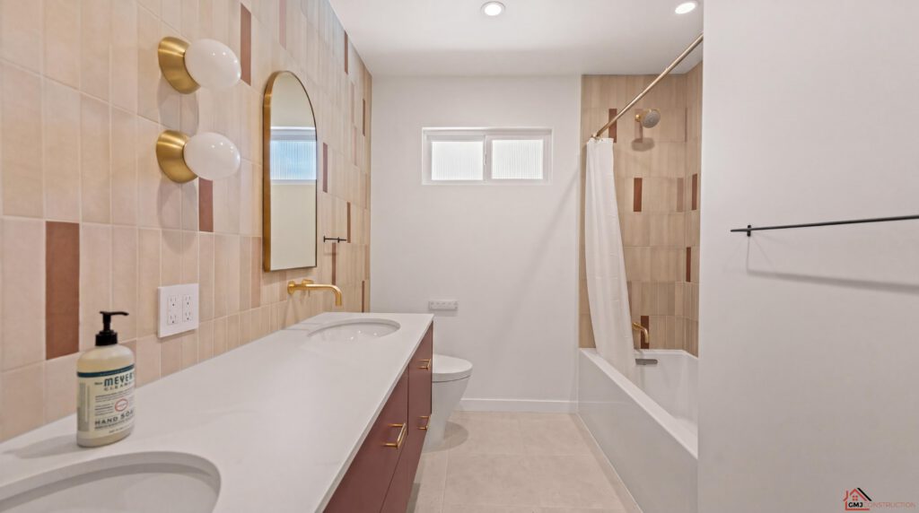 Double-vanity bathroom with arched mirrors and a white tub-shower