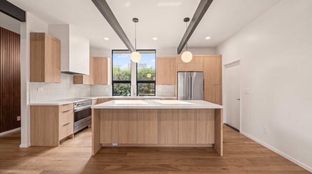 Eleanor Drive kitchen in San Mateo with light wood cabinetry, an island and exposed beams