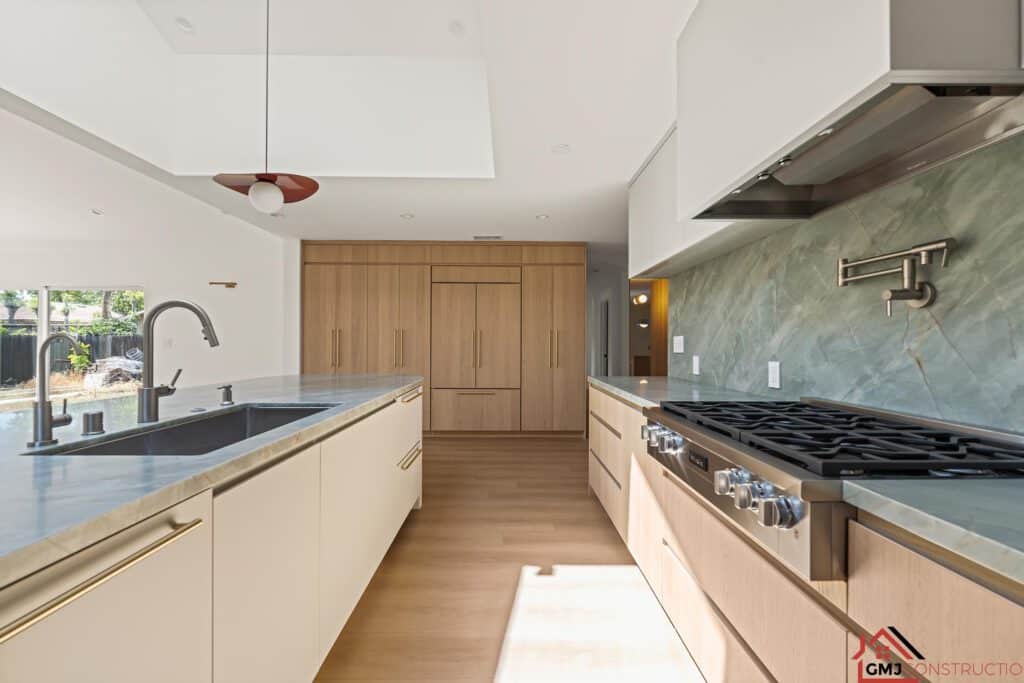 Kitchen range and cabinetry beside the island at Samson Way