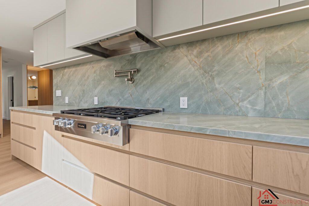 Kitchen range, wall-mounted pot filler and green-veined backsplash