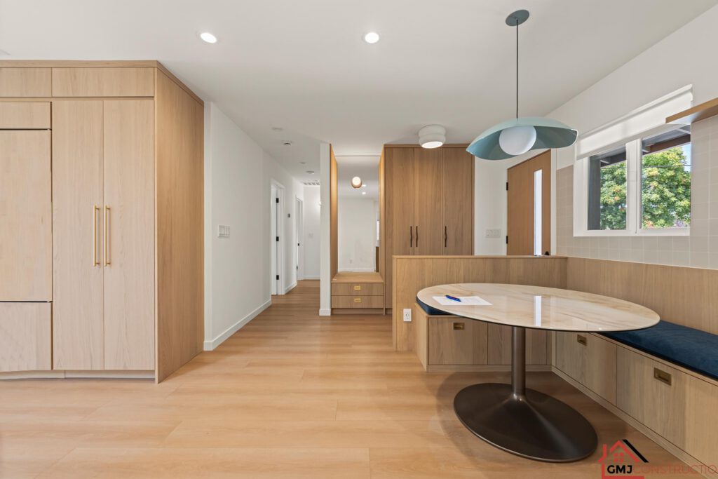 Built-in dining bench and round table beside wood cabinetry