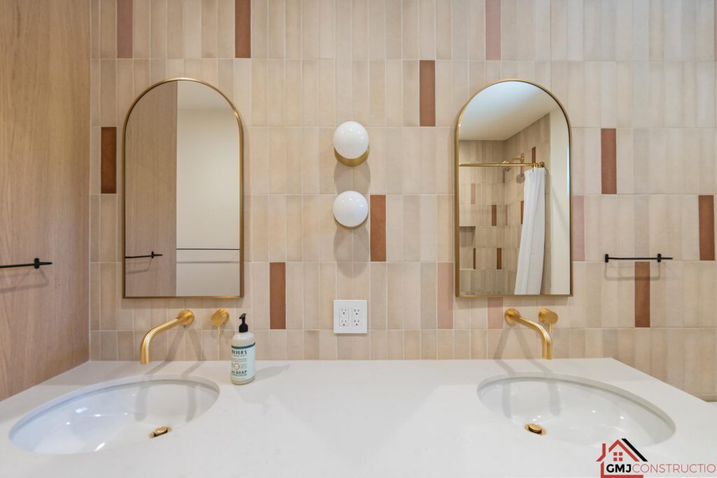 Paired arched mirrors and gold-toned fixtures above the bathroom double vanity