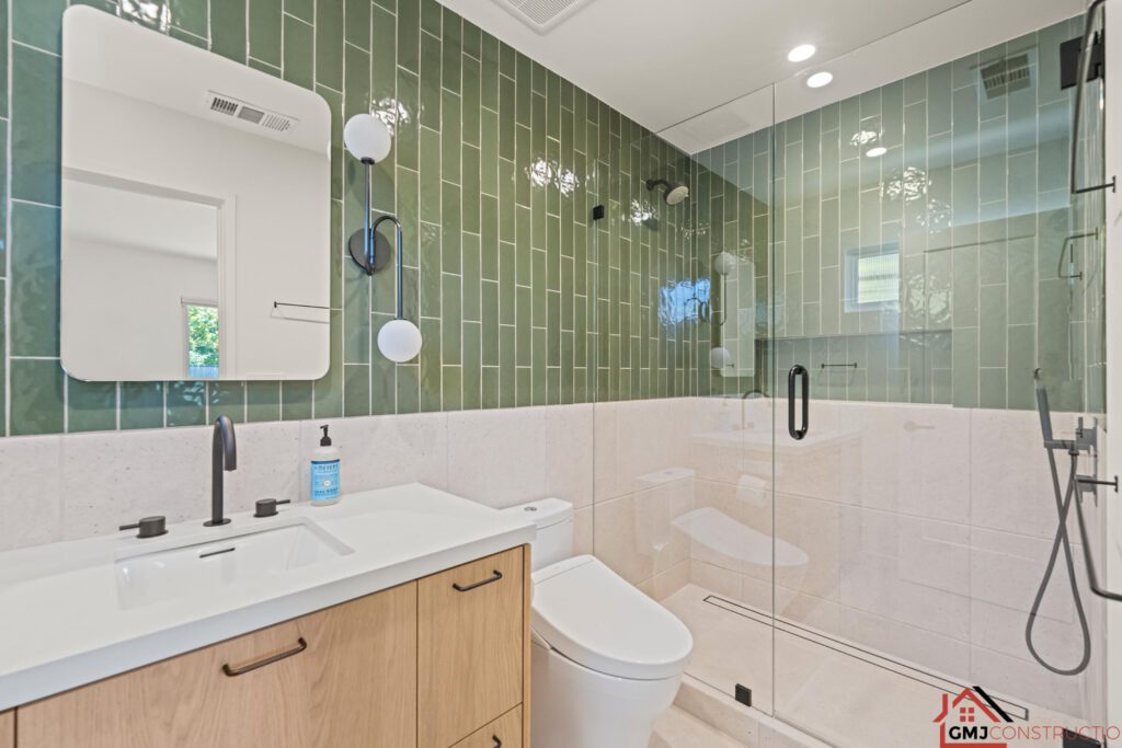 Green-tiled bathroom at Samson Way with a wood vanity and clear glass shower enclosure