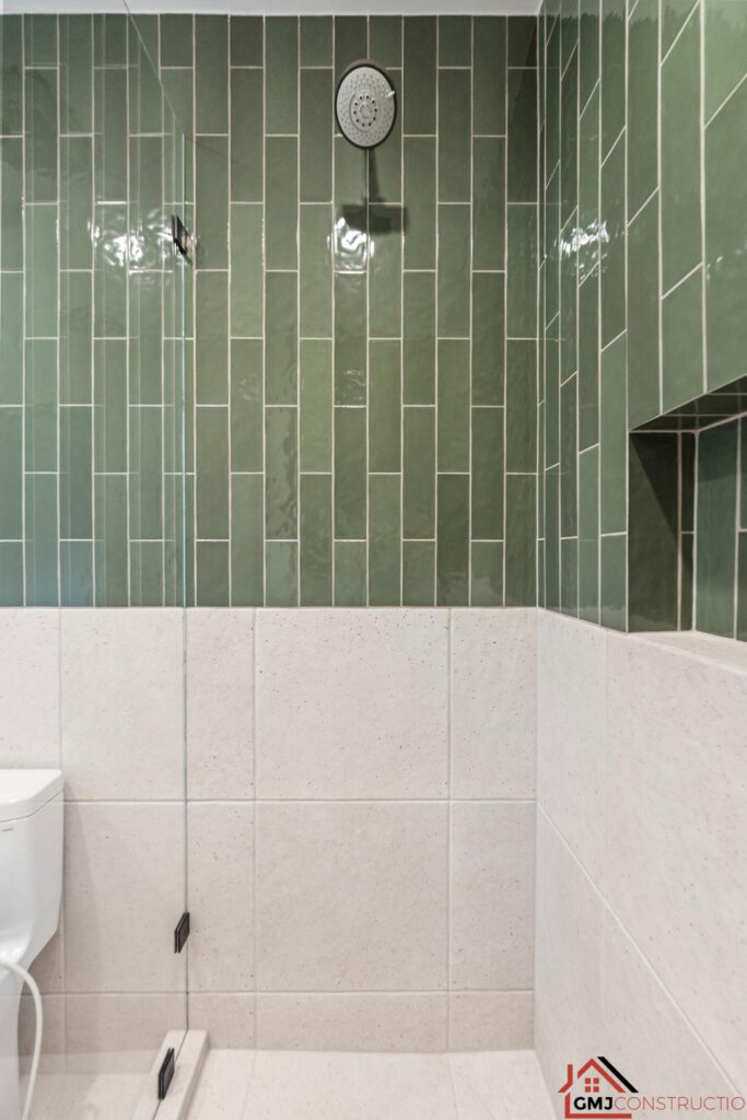 Showerhead and recessed niche in the green-tiled Samson Way bathroom